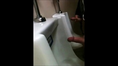 two slim dicks getting wanked at the urinals